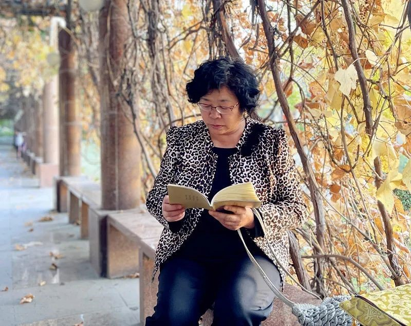 卫星广场长廊秋色迷人，居民正在阅读。

