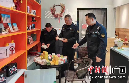 图为工作人员查获非法经营电子烟产品 王靖 摄