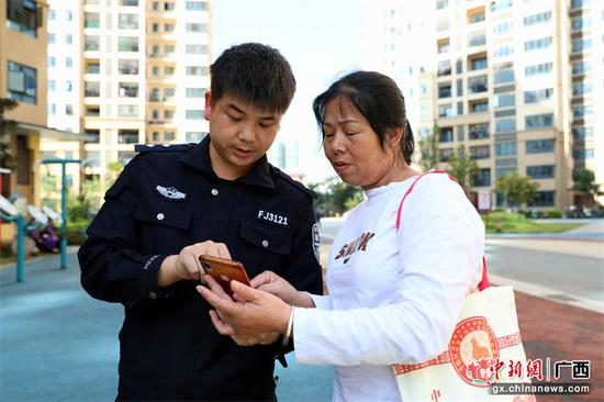 图为辅警在指导老人安装“国家反诈中心” app。甘勇 摄