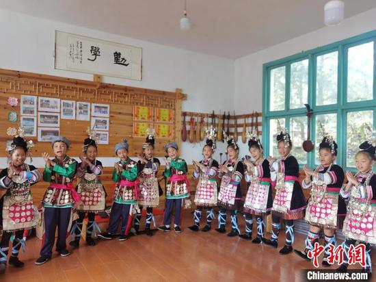 10月20日，小黄小学少儿歌队成员蒋晗明(中)与同学在学校的音乐教室练习侗族大歌。周燕玲 摄