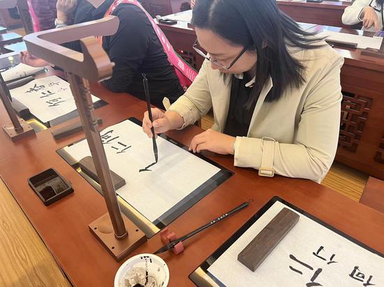 10月20日，第82届中国教育装备展示会在天津启幕，图为一观众现场体验“智慧书法教室”。王君妍摄