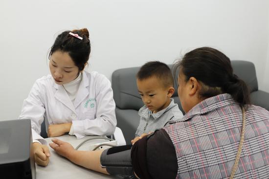 巢凤街道茶马古镇社区卫生服务站，医护人员正给群众测血压。刘麟摄