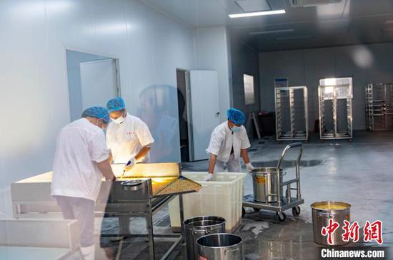 工人在贵州从江县一家公司的百香果提酱车间生产线上忙碌。吴德军 摄