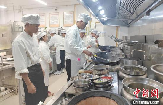 图为“粤菜师傅”培训基地内，同学们正在进行烹饪实训。邓万里摄