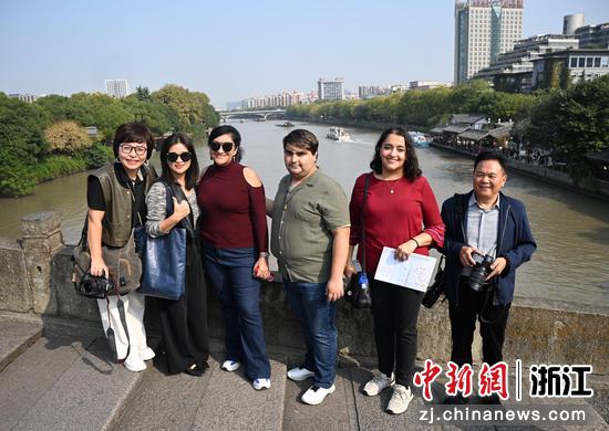 活动参与者在大运河南端拱宸桥上拍照。中新社记者 王刚 摄