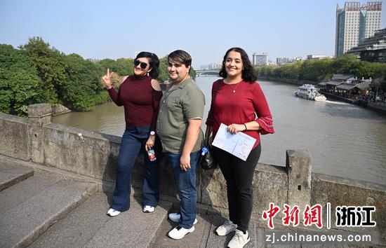 活动参与者在大运河南端拱宸桥上拍照。中新社记者 王刚 摄