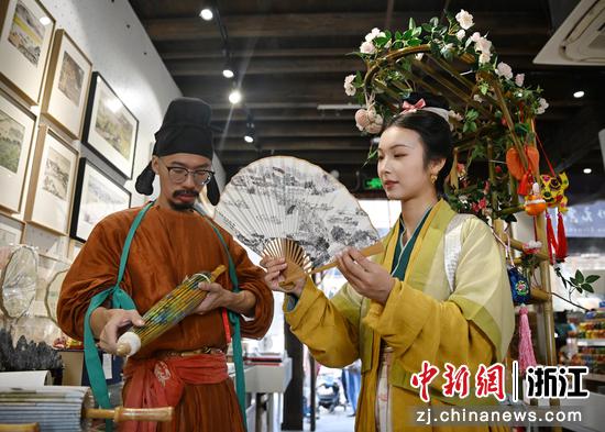陈喜悦（右）和一青在挑选绸伞和扇子。中新社记者 王刚 摄