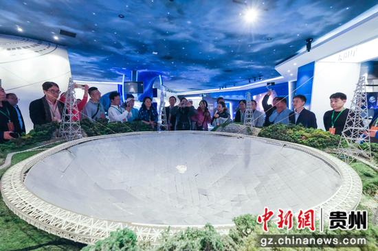 图为海外华文媒体高层一行参观天文体验馆，媒体团在500米口径球面射电望远镜模型前了解“中国天眼”的建设与发展。徐雁 摄