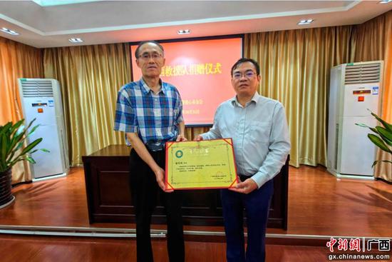 图为吴玉明代表高永褀先生接受捐赠荣誉证书。