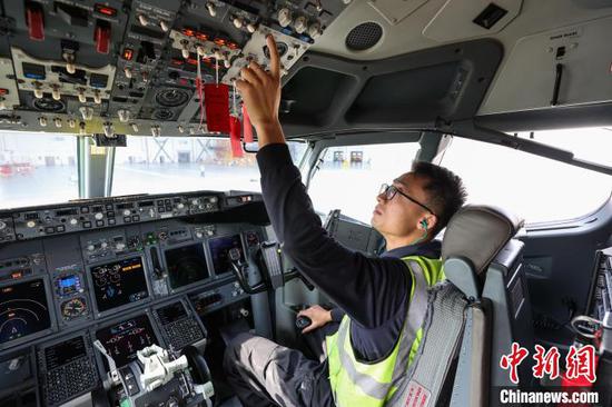 11月8日，贵州省贵阳市，一名机务在飞机驾驶舱调试设备。中新网记者 瞿宏伦 摄