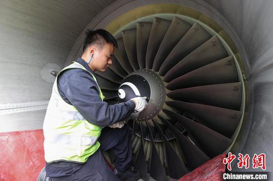 11月8日，贵州省贵阳市，一名机务在检查飞机发动机前整流锥。中新网记者 瞿宏伦 摄