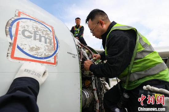 11月8日，贵州省贵阳市，机务人员在检修飞机发动机的供油管路。中新网记者 瞿宏伦 摄