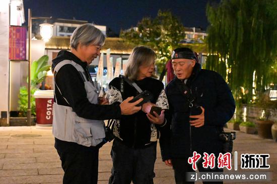 多名摄影家在拍摄中交流探讨。中新社记者 王刚 摄