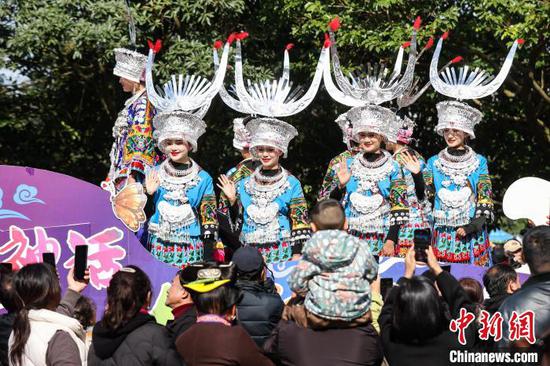 穿着节日盛装的苗族民众向游客挥手。中新网记者 瞿宏伦 摄