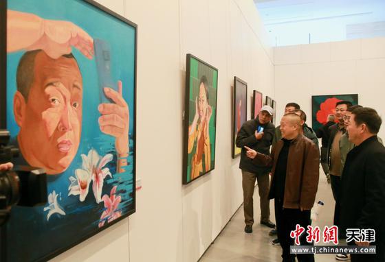 宋海增（中）在画展现场介绍作品。 天津市群艺馆供图