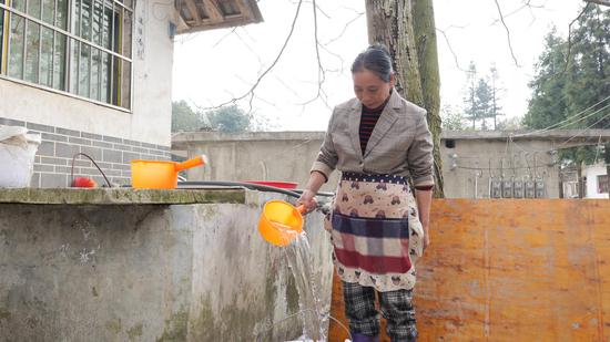 海坝村村民正在自己家院子里取水