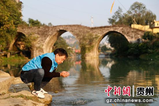 图为2023年11月21日，五马镇生态环境保护协会副会长郭小勇在五马河巡河，郭小勇以前曾是当地酒厂的一名员工。