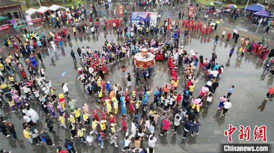 2023贵州铜仁·梵净山冬季马拉松欢乐跑终点，跑友和当地村民一起跳舞。铜仁市融媒体中心供图