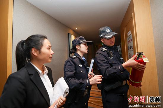 邓哲（中）和八弓派出所民警在酒店进行安全检查。吴芳秋 摄