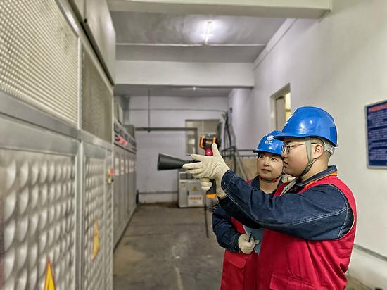 国网乌鲁木齐供电公司员工在新疆“海鲜”养殖基地配电室进行巡视测温。（丁瑞 摄）