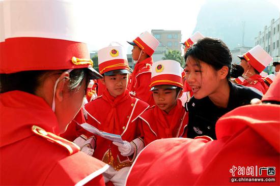 图为民警在校园仪仗队汇演现场开展普法宣传。甘勇 摄 图为民警在校园仪仗队汇演现场开展普法宣传。甘勇 摄
