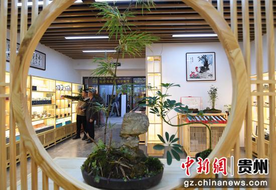 12月1日，在贵钢花鸟商业街区三楼的“德亿馨”茶器、瓷工、艺品商铺内，商户正在给客人介绍茶器。