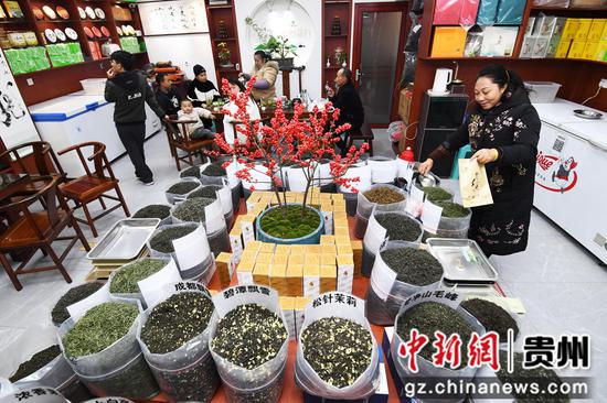 12月1日，在贵钢花鸟商业街区一楼的“碧黔茶行”商铺内，商户正在给客人装茶。
