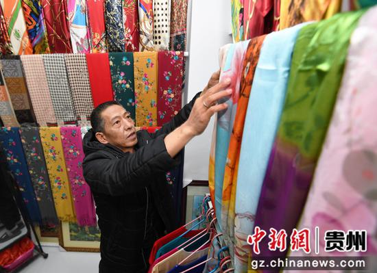 12月1日，在贵钢花鸟商业街区三楼的“苏州刺绣”商铺内，商户正在整理丝绸围巾。