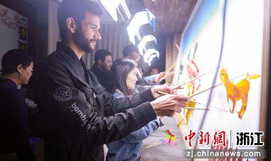 外国友人在龙港市九龙河社区体验皮影戏。龙港市融媒体中心 供图