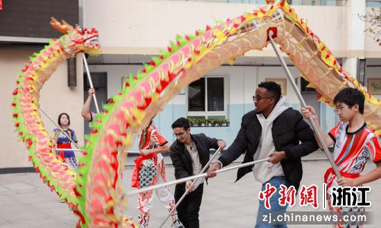 外国友人在龙港市第四小学体验舞龙表演。龙港市融媒体中心 供图