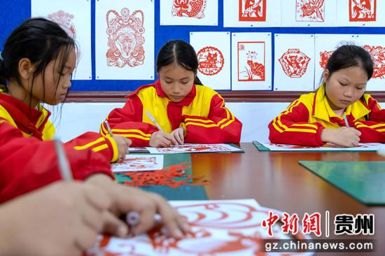 12月4日，学生在贵州省罗甸县第三小学学习剪纸。