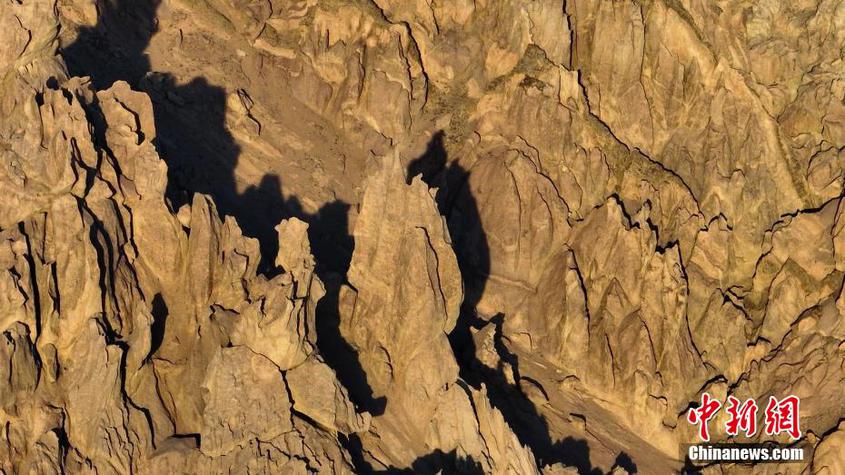 托克逊盘吉尔怪石林平均海拔1200米，总面积约1平方公里，距托克逊县城55公里。石林是由溶蚀和风蚀作用形成的峰林地貌，单体构造一般为2～5米，大型的高度达十几米，岩体多为石炭纪火山岩和角砾凝灰岩，呈青灰或褐红色，岩石中含有丰富的碳酸钙。这种怪石林，是在特定的自然条件下形成的一种石炭系火山岩山岳型石林，是迄今国内发现的惟一的火成岩风蚀石林区，形态完整，是神奇的风蚀地貌自然博物馆。图为形似火炬的怪石。 李靖海 摄