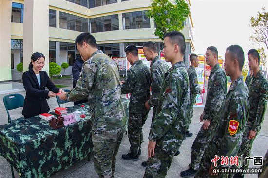 图为宣讲小组向武警官兵赠送法律书籍。刘志豪  摄
