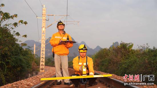 该段青年职工在焦柳铁路大岭站至古竹站区间用激光测量仪检测接触网导高数据。JPG