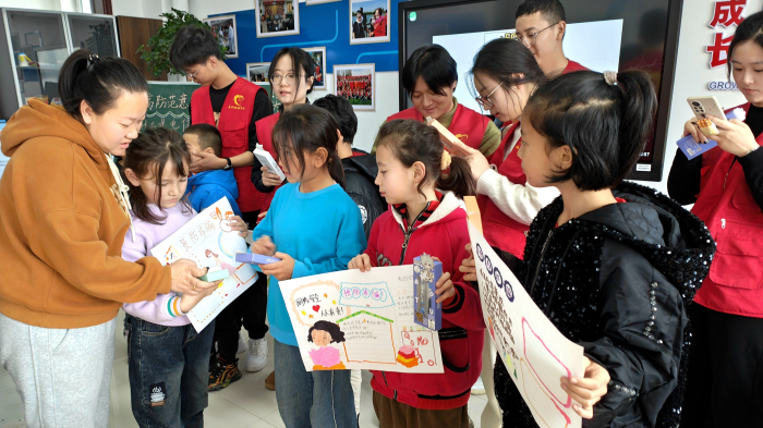12月16日,察布查尔镇石榴籽小课堂内,喜利妈妈社会服务中心工作人员在给“石榴籽小课堂”的孩子们和盐城师范学院的支教大学生志愿者颁发小礼品。华岩明摄 12月16日,察布查尔镇石榴籽小课堂内,喜利妈妈社会服务中心工作人员在给“石榴籽小课堂”的孩子们和盐城师范学院的支教大学生志愿者颁发小礼品。华岩明摄