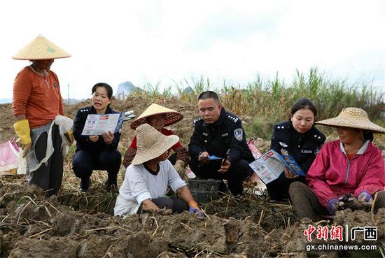 图为民警辅警在和挖马蹄的村民开展法治宣传。甘勇 摄