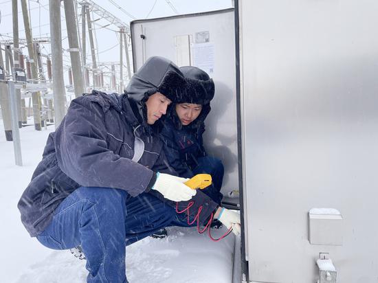 12月13日，国网哈密供电公司工作人员在220千伏山北变电站对充油充气设备油位和压力进行检查。姚自阳 摄