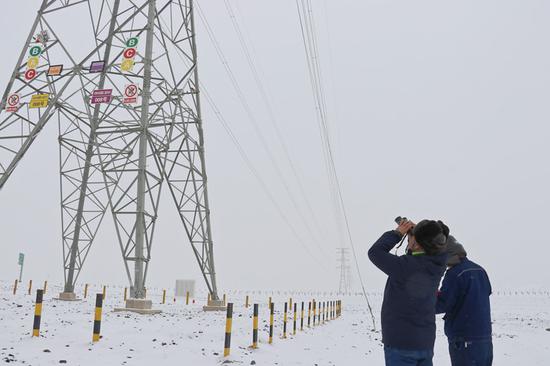 12月13日，国网吐鲁番供电公司输电运检人员在巡视线路。徐自鹏 摄