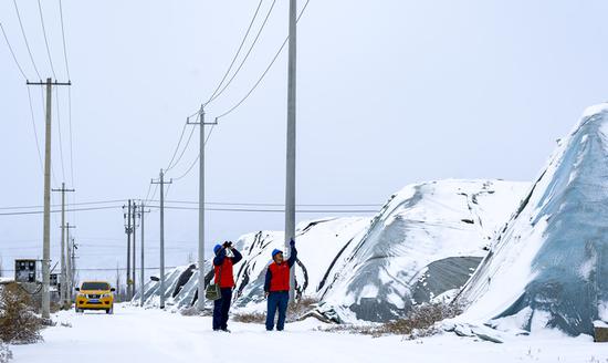12月14日,巴州和硕县出现小到中雪,国网巴州供电公司员工前往新疆新投绿环种植有限责任公司蔬菜大棚种植基地,对该公司现代化智慧农业大棚用电设备进行巡视检查,保障寒潮天气下蔬菜大棚供暖用电。史俊毫 摄 12月14日,巴州和硕县出现小到中雪,国网巴州供电公司员工前往新疆新投绿环种植有限责任公司蔬菜大棚种植基地,对该公司现代化智慧农业大棚用电设备进行巡视检查,保障寒潮天气下蔬菜大棚供暖用电。史俊毫 摄