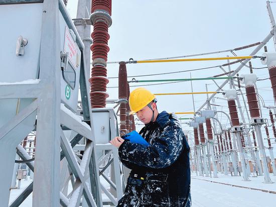 12月11日，国网新疆超高压分公司750千伏乌北变电站值班员开展大雪特巡工作。尹杰 摄