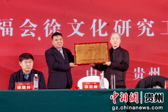 图为中国徐福会王海民会长为徐文化研究工作委员会徐后峰主任颁牌。
