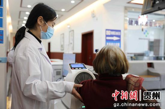 村民在旺草镇卫生院医防融合诊前服务台测量血压。王婵娟 摄