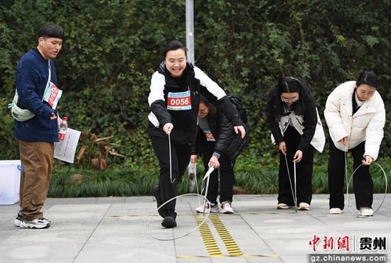 12月28日，在贵阳市南明区“庆元旦·迎新年”职工趣味健步走系列活动现场，职工代表正在参与铁环独木桥闯关趣味挑战活动。
