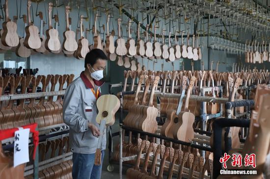 2015年国家机械委质量司正式授予正安县“中国吉他制造之乡”称号。2021年，中国轻工业联合会、中国乐器协会授予正安县“中国吉他之都”称号。图为工人在检查半成品的尤克里里。瞿宏伦 摄