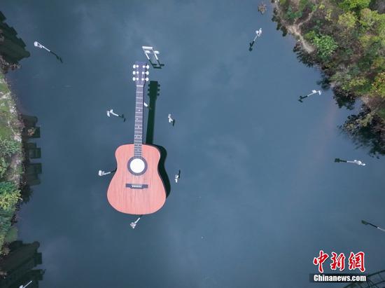 正安县城，一把吉他雕塑横卧在河面上，从空中俯瞰，吉他雕塑与周边的环境相映成趣，自成一景。瞿宏伦 摄
