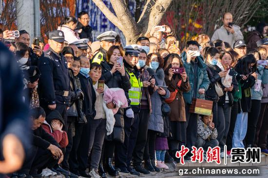 2023年12月31日，市民在贵州省毕节市威宁彝族回族苗族自治县街头观看万人万米长跑赛活动。