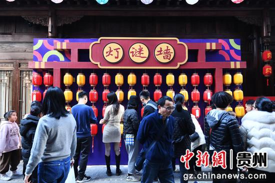 12月31日，市民游客在贵阳市南明区曹状元街区灯谜墙猜谜。