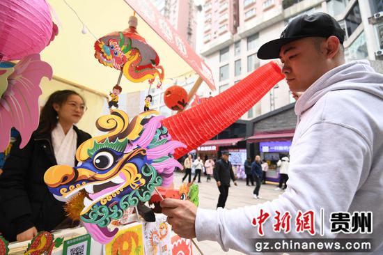 12月31日，市民旅客在贵阳市南明区曹状元街区选购非遗商品。