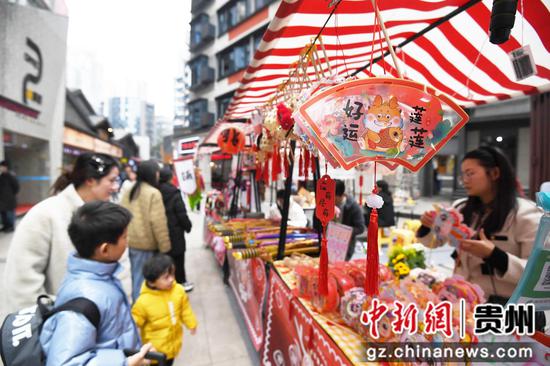 12月31日，市民旅客在贵阳市南明区曹状元街区选购迎新商品。