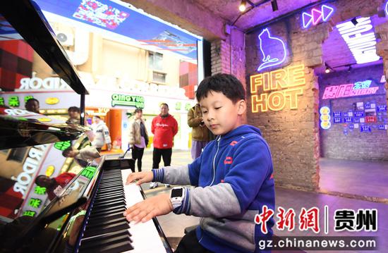 12月31日，在贵阳市南明区青云市集内，一位小朋友正在钢琴演奏《童年的回忆》。